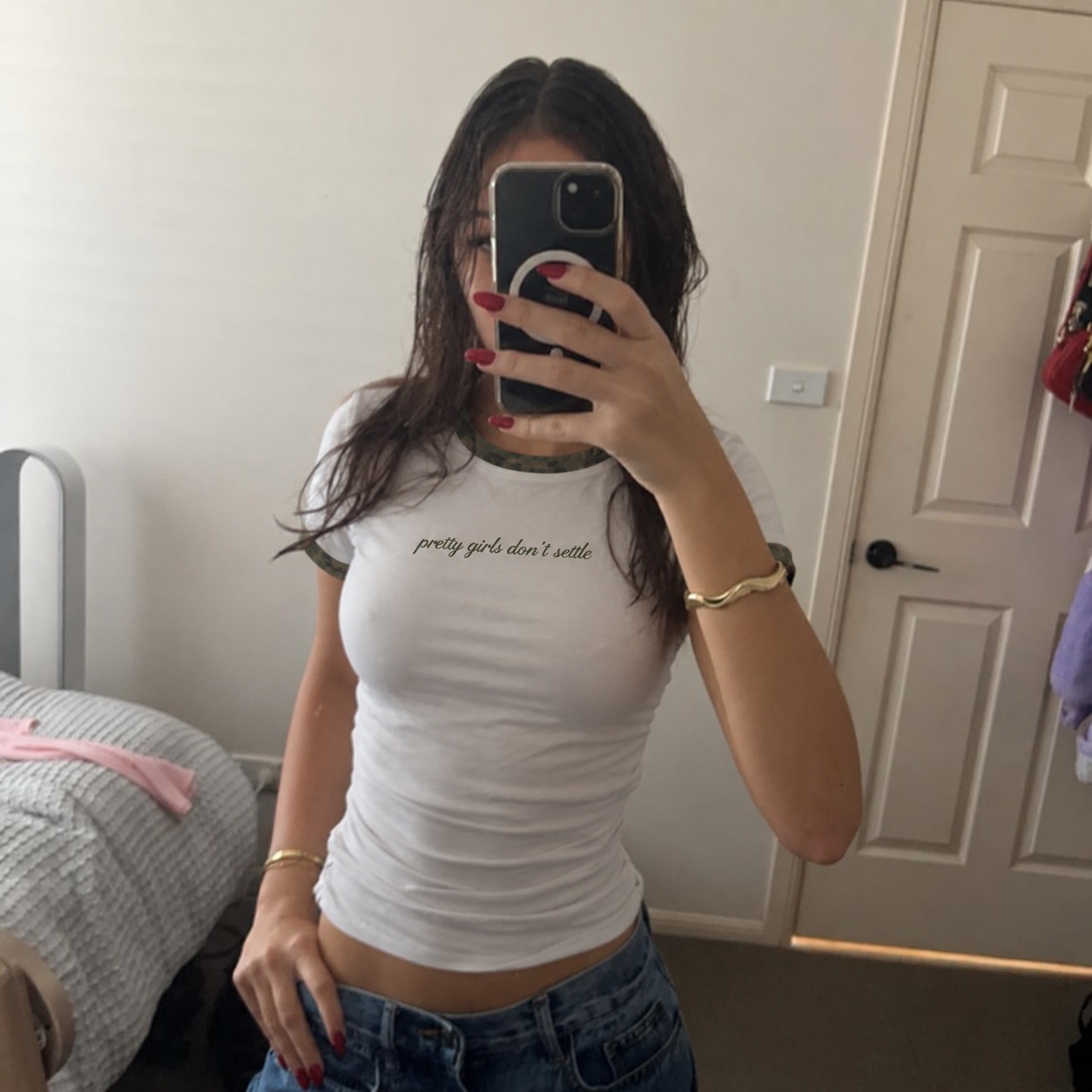 Pretty Girls Don't Settle white and camo baby tee worn in a bedroom mirror selfie with low-rise jeans